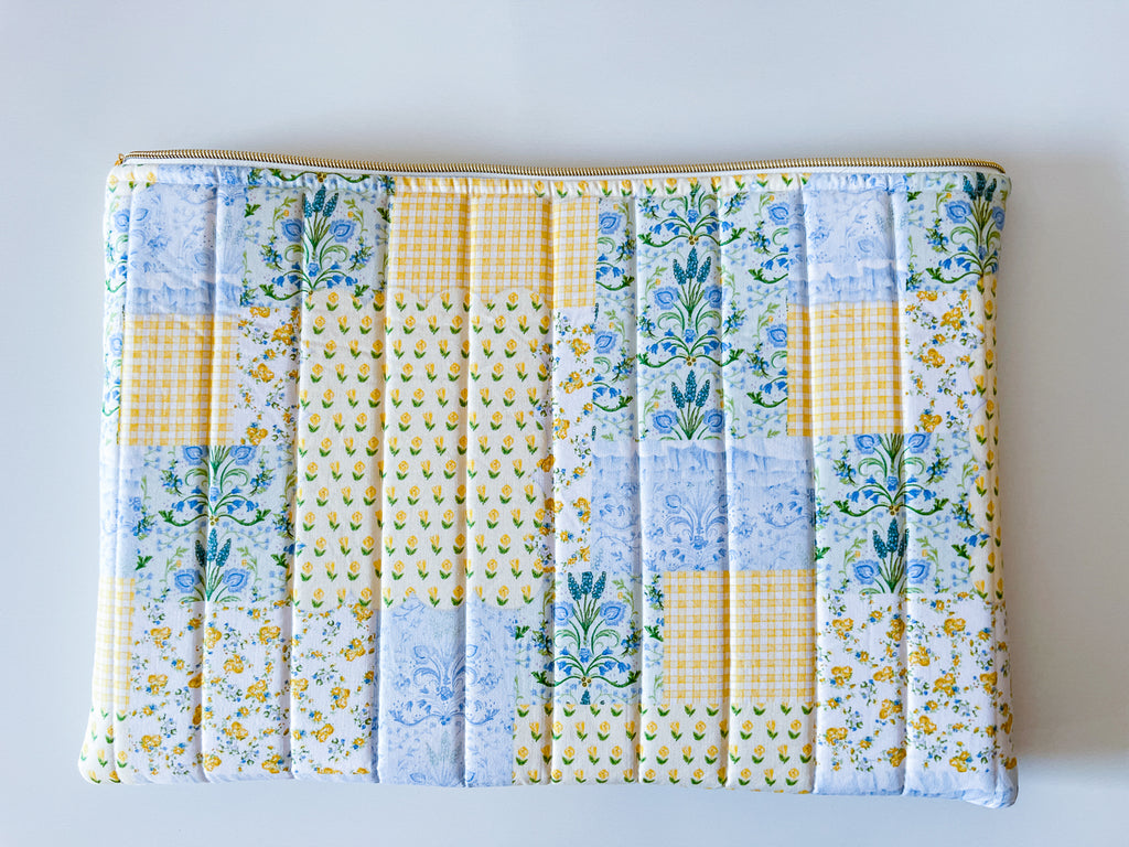back of laptop sleeve quilted patchwork print design with florals yellow blue green colors on white background